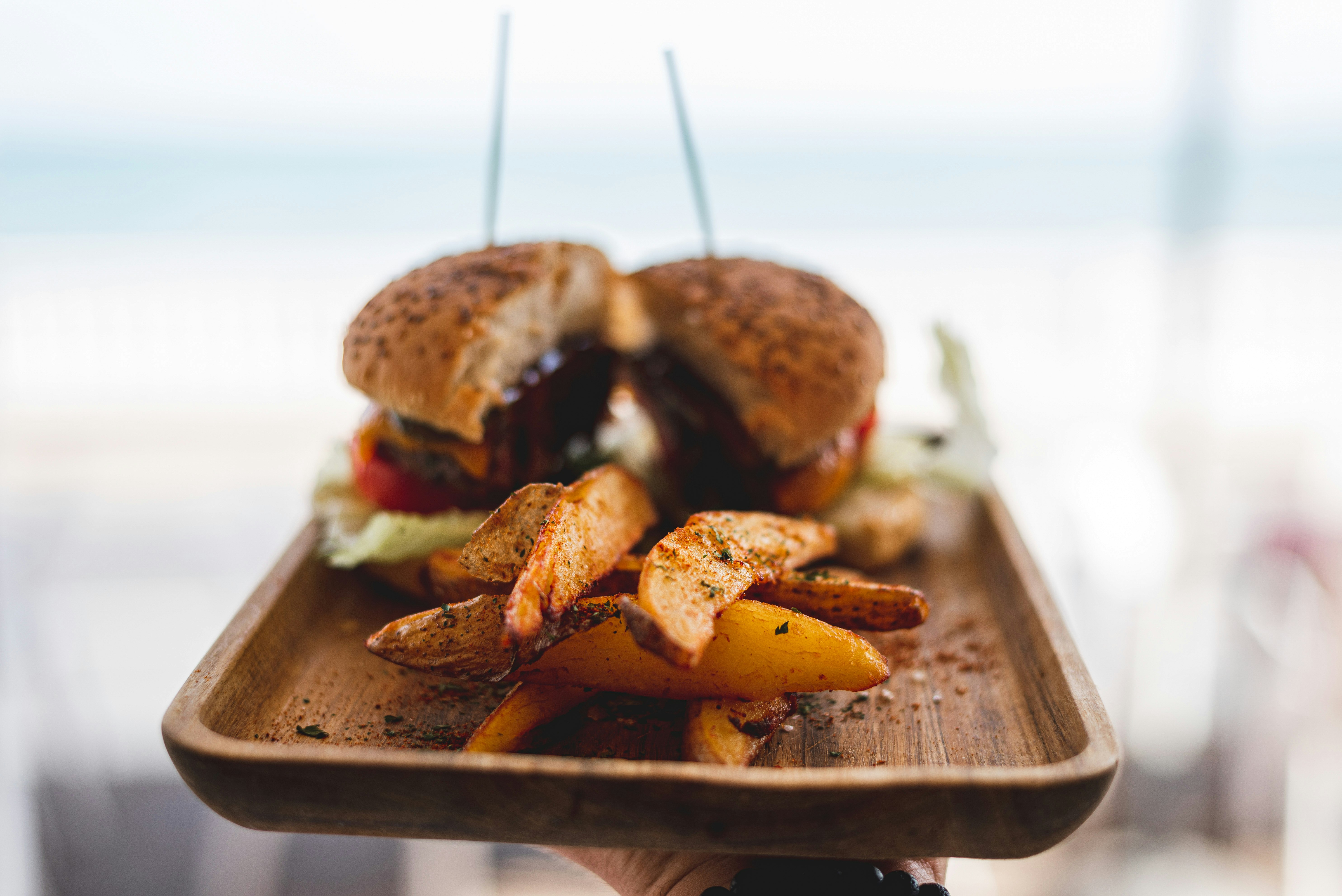 burger with patty and cheese on brown wooden tray